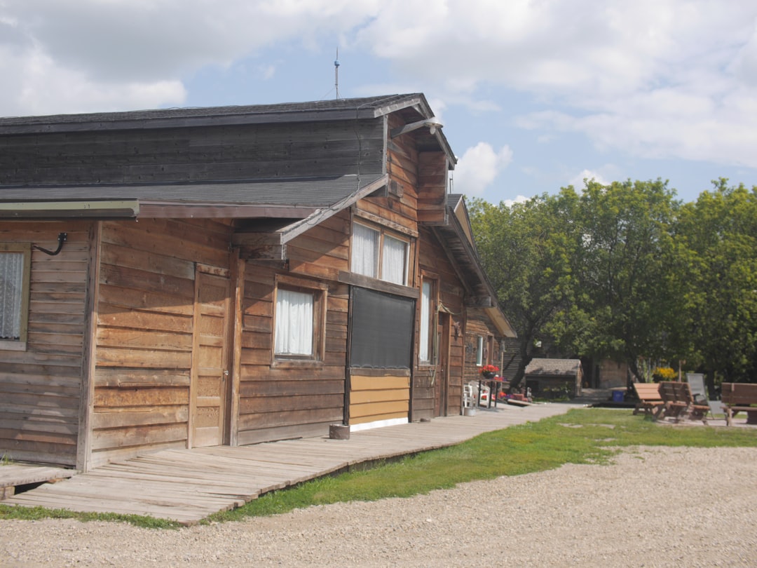 Rustic wooden building with trees and outdoor seating area.