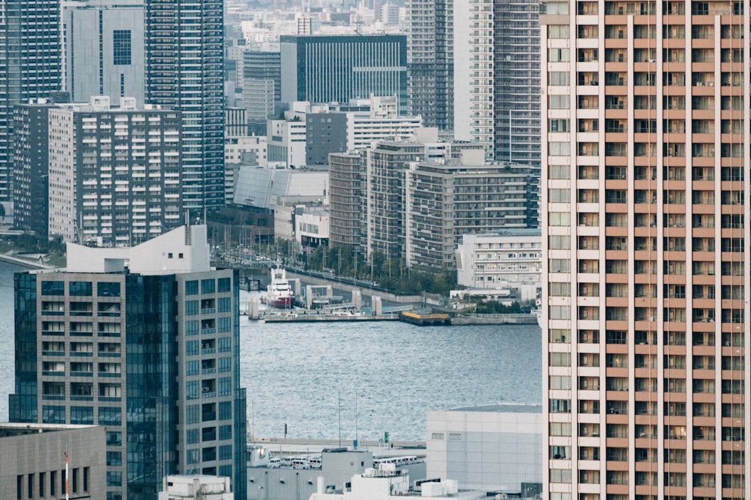 Modern skyline with tall buildings and water in the foreground.