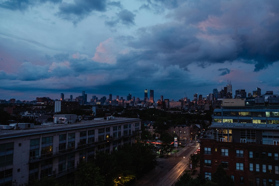 City with skyscrapers under blue and white skies at night.