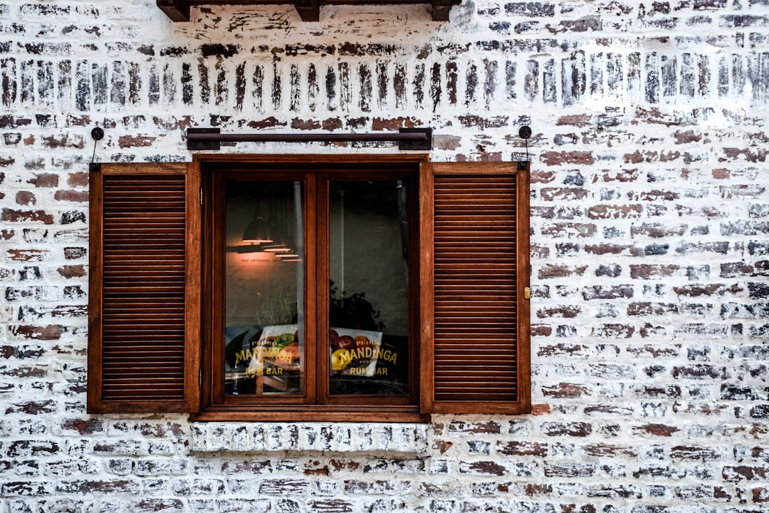 Glass window with a brown wooden frame, highlighting Spanish architecture.
